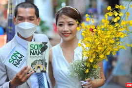 Chú rể Nguyễn Anh Tú và cô dâu Nguyễn Thị Tuyết Mai sung sướng đón nhận những ấn phẩm được gửi tặng. Ảnh: Nguyễn Á