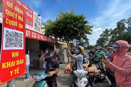 Người dân quét mã khai báo y tế trên điện thoại tại trạm kiểm soát trên đường Nguyễn Kiệm (Gò Vấp) ngày 7/6 (Ảnh: SGGP) 