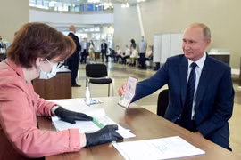 Tổng thống Nga V.Putin trình hộ chiếu của mình tại trạm bỏ phiếu về sửa đổi Hiến pháp tại một trạm bầu cử ở Moscow ngày 01/07/2020 (Ảnh:TASS). 