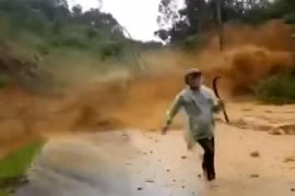 Người đi đường thất thần tháo chạy khỏi đống đất đá từ trên cao đổ xuống (ảnh cắt từ clip)