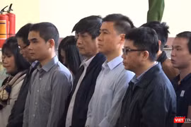 Bị cáo Nguyễn Thanh Hóa (người mặc áo khoác đen đứng giữa) trong phiên tòa xét xử vụ đánh bạc ngàn tỷ.