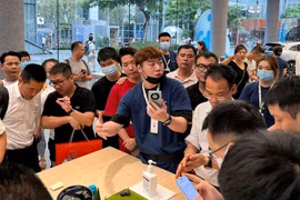 Một nhân viên giới thiệu điện thoại thông minh Huawei Mate 60 tới khách hàng tại cửa hàng của Huawei ở Thâm Quyến (ảnh: Reuters)