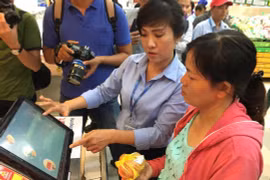 Nhân viên Co.opmart Foodcosa Quang Trung (Gò Vấp) hướng dẫn khách hàng cách kiểm tra nguồn gốc thịt heo bằng máy soi đặt tại siêu thị