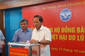 Bộ trưởng Trương Minh Tuấn (bên phải) và thứ trưởng Nguyễn Minh Hồng ủng hộ đồng bào lũ lụt miền Trung.