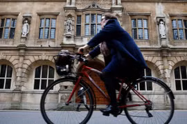 Một người phụ nữ đi xe đạp bên cạnh trường Oriel College ở Oxford, Anh (ảnh: Thomson Reuters)