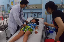 TS.BS Nguyễn Minh Tuấn thăm khám bệnh nhi sốt xuất huyết phải chuyển viện từ BV Quận 12 đến BV Nhi Đồng 1- Ảnh: Hòa Bình