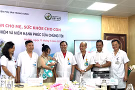 Lãnh đạo BV Phụ sản Trung ương trao em bé cho bố mẹ cháu và chúc mừng gia đình