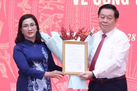 Trưởng Ban Tuyên giáo Trung ương Nguyễn Trọng Nghĩa trao quyết định cho bà Đinh Thị Mai. Ảnh: TTXVN