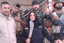 "Bà nội trợ" Wahida Mohamed Al-Jumaily đứng bên các chiến binh dưới quyền. (Nguồn: Independent).