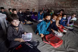 Trẻ em Afghanistan theo bố mẹ chạy sang Pakistan tị nạn (Ảnh Reuters).