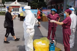 Nhân viên chống dịch tiến hành khử trùng các khu vực có người bị bệnh sinh sống ở thành phố Đại Liên (Ảnh: Đông Phương).
