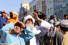  Dân chúng xem thi thể bị Taliban treo lên thị chúng ở thành phố Herat (Ảnh AP).