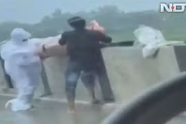 Hình ảnh một nhân viên y tế và người nhà ném thi thể bệnh nhân COVID-19 xuống sông trên NDTV (Ảnh: Chinatimes).