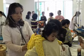 Bác sĩ khám cho trẻ mắc cúm mùa