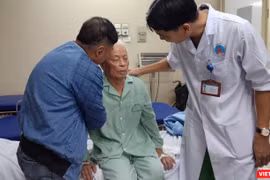 Bác sĩ Trịnh Tú Tâm và người thân của ông Đ. kiểm tra tình trạng sức khỏe của ông sau khi phẫu thuật bơm xi măng sinh học.