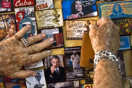 Một nghệ sĩ người Cuba trưng bày nhiều hình ảnh liên quan đến tổng thống Mỹ Barack Obama ở cửa hàng bán đồ lưu niệm tại thủ đô Havana, Cuba - Ảnh:AP