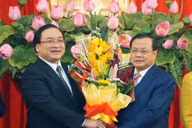 Ông Phạm Quang Nghị (phải) tặng hoa chúc mừng tân Bí thư Hà Nội Hoàng Trung Hải trong ngày nhậm chức