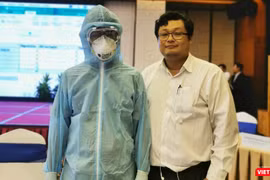 BS.TS Huỳnh Minh Tuấn (bên phải) hướng dẫn nhân viên y tế mặc các loại phương tiện phòng hộ cá nhân (Ảnh: TB) 
