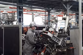 Công nhân Công ty VPIC thực hiện ráp phần khung sườn chiếc xe máy Ducati lên khuôn, các việc còn lại sẽ do robot thực hiện. Mỗi công nhân sẽ phụ trách 2 robot. Ảnh: Hà Thế An.
