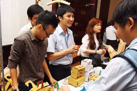 Anh Đỗ Hữu Tân (giữa) đang giới thiệu sản phẩm của mình với khách hàng. (Ảnh: Magix)