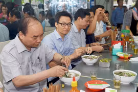 Thủ tướng và đoàn kiểm tra dừng chân, dùng điểm tâm tại một quán ăn đường phố thuộc phường Tân Thành, TPHCM. Ảnh: VGP/Quang Hiếu. 
