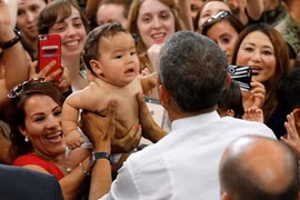 Em bé lập tức nín khóc sau khi được ông Obama bế. Ảnh: Reuters