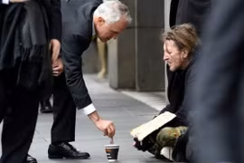 Ông Malcolm Turnbull cho tiền người ăn xin trên đường phố Melbourne hôm 18/8 - Ảnh: AAP