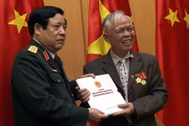 Bộ trưởng Phùng Quang Thanh tặng sách ảnh quốc phòng Việt Nam cho cựu chiến binh Trung Quốc - Ảnh: Phan Hậu