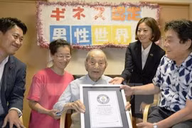 Cụ Yasutaro Koide (giữa) nhận giấy chứng nhận Kỷ lục Thế giới Guinness cụ ông cao tuổi nhất thế giới tại Nagoya ngày 21/8 vừa qua. (Ảnh: Kyodo/TTXVN)