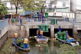 Hiện việc vớt lục bình, rong cỏ chủ yếu bằng xuống. Ảnh: Sơn Hòa