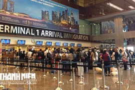 Khách xếp hàng làm thủ tục nhập cảnh tại sân bay Changi của Singapore - Ảnh: Thục Minh