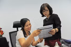 Bà Việt Hương - giám đốc nhân sự (trái) và bà Quế Chi - giám đốc dự án, công ty xây dựng trên địa bàn TP.HCM - đang tính toán lại nhân sự tham gia đóng bảo hiểm xã hội năm 2016 cho toàn công ty - Ảnh: Tự Trung