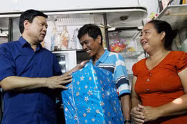 Bí thư Thành ủy TP.HCM Đinh La Thăng trong một lần tặng quà và động viên gia đình anh Đào Tiến Dũng (quận 8) ủng hộ chủ trương di dời nhà ven Kênh Tẻ của TP trong thời gian tới. Ảnh: HOÀNG GIANG