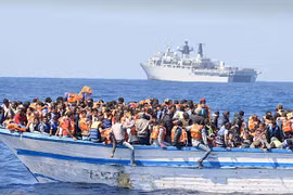 Hàng trăm người di cư chen chúc trên một thuyền nhỏ ở ngoài khơi Libya. Ảnh: REX