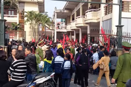 Học sinh và tiểu thương chợ Nành tại trụ sở UBND xã Ninh Hiệp (Gia Lâm, Hà Nội) sáng 21/12. Ảnh: Tuổi Trẻ.