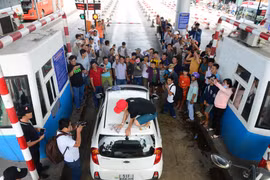 Tài xế Võ Mạnh Hảo dừng xe lau kính giữa trạm thu phí. Ảnh: Zing
