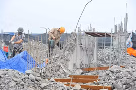 Công nhân tiến hành khoan, phá dỡ phần công trình xây dựng trái phép ở toà nhà số 8B Lê Trưc, Hà Nội, sáng 6/3. (Ảnh: Minh Đức/TTXVN)