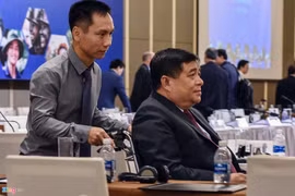 Bộ trưởng Nguyễn Chí Dũng phải ngồi xe lăn và nhờ người hỗ trợ khi đến dự diễn đàn. Ảnh: Việt Linh.
