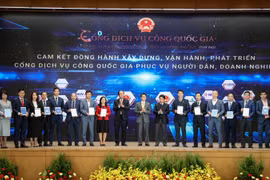Phó Tổng giám đốc VPBank Đinh Văn Nho (thứ 5 từ trái sang) và các doanh nghiệp ký cam kết đồng hành xây dựng, phát triển Cổng Dịch vụ công quốc gia. (Ảnh: Minh Sơn/Vietnam+)