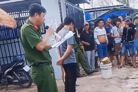 Trong đoạn clip, công an cầm micro đọc rõ to hành vi mua bán dâm và yêu cầu những người bị bêu danh bước lên cho người đi đường nhìn rõ mặt. Ảnh cắt từ video.