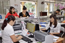 Giao dịch viên phục vụ khách hàng từ mùng Ba Tết. Ảnh: Minh Đàm