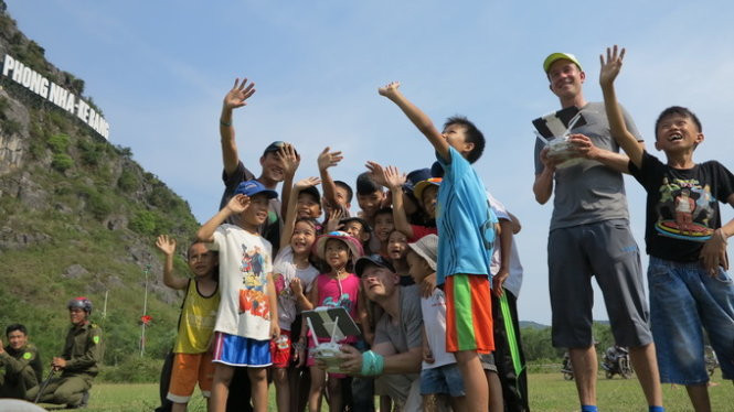 Trẻ em Quảng Bình thích thú theo dõi hai chuyên gia của ABC kiểm tra thiết bị quay phim từ xa (flycam) - Ảnh: Lê Nam