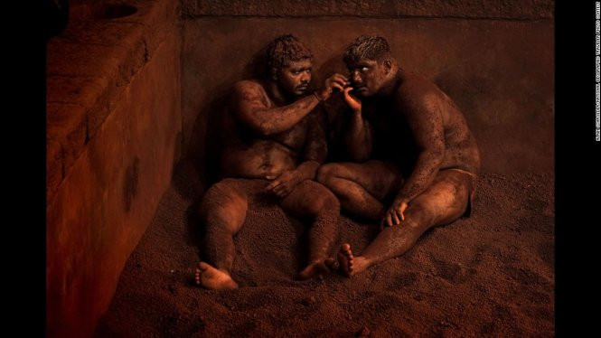 Kushti - một nghi thức truyền thống đấu vật trong bùn của Ấn Độ. Các đô vật sẽ nghỉ ngơi và massage thư giãn trong hầm đất sét để thả lõng cơ sau những buổi đấu vật mệt mỏi - Ảnh đoạt giải khuyến khích của Alain Schroeder/hạng mục Spontaneous moments
