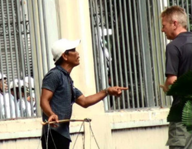 Một người trong nhóm bán dừa trên đường Nam Kỳ Khởi Nghĩa(TP.HCM) đang chèo kéo, yêu cầu du khách nước ngoài phải trả 5 USD (tương đương trên 100.000 đồng)/trái dừa - Ảnh: Đức Phú