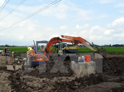 Đơn vị kiểm định chất lượng bê tông tiến hành khoan trụ bê tông cột điện cao thế để lấy mẫu kiểm định chất lượng. (Ảnh: Văn Đạt/TTXVN)