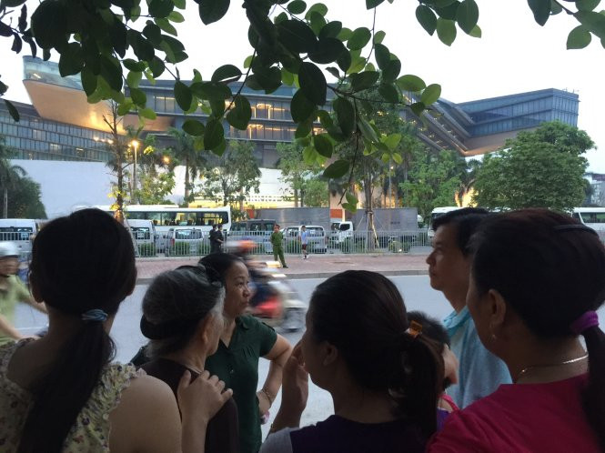 Người dân tập trung hai bên đường chuẩn bị đón tổng thống - Ảnh: Xuân Long