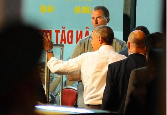 Tổng thống Mỹ vẫy chào người dân và bước vào quán bún chả ở đường Lê Văn Hưu, Hà Nội. Ảnh: Việt Hùng