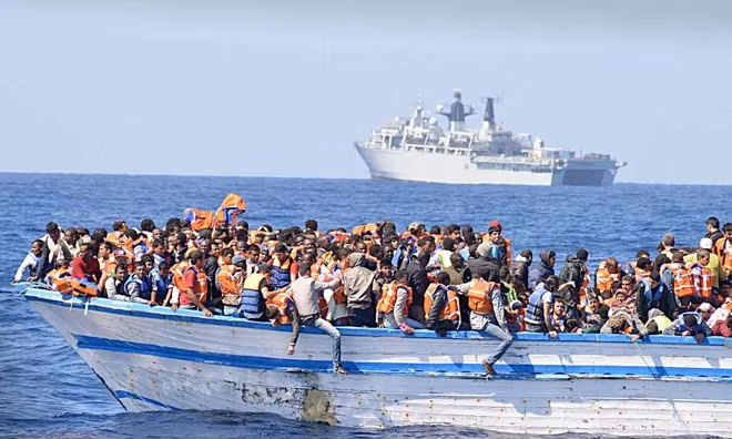 Hàng trăm người di cư chen chúc trên một thuyền nhỏ ở ngoài khơi Libya. Ảnh: REX