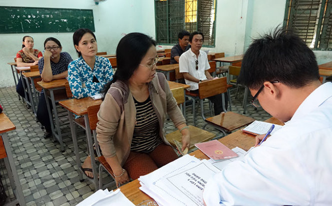 Phụ huynh đến nộp hồ sơ nhập học cho con đều luôn cầm theo hộ khẩu - Ảnh: Như Hùng