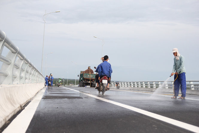 Công nhân đang chùi rửa, mài dũa mặt cầu trước giờ thông xe